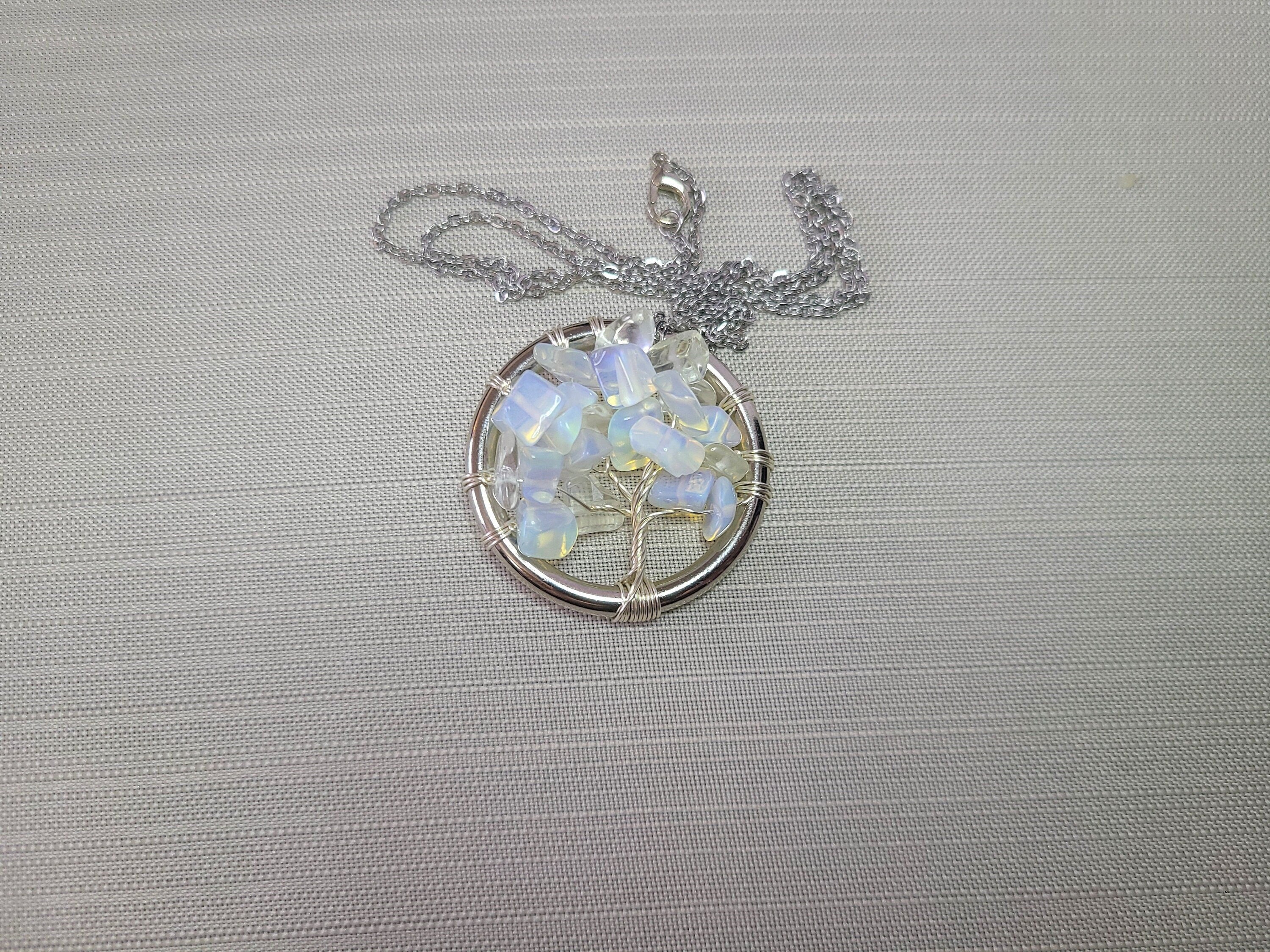 Silver necklace with a circular pendant on a textured gray background