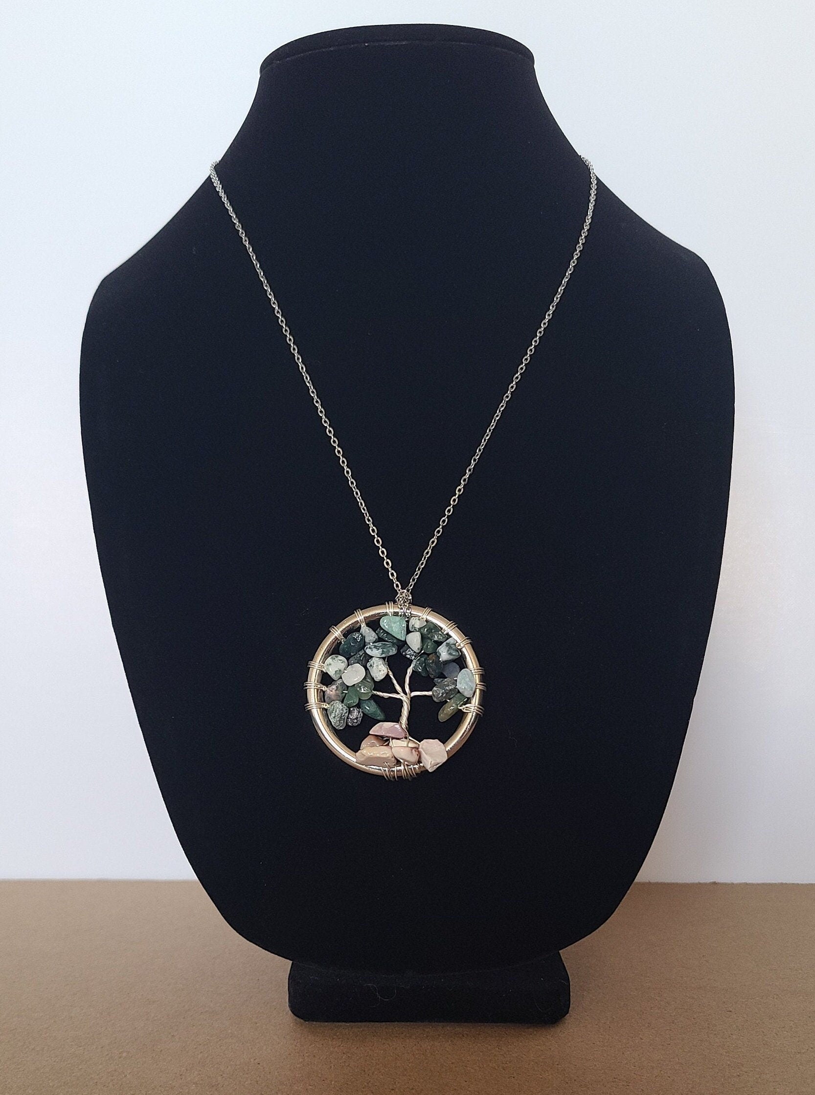 Necklace with a circular pendant on a black velvet stand against a white background