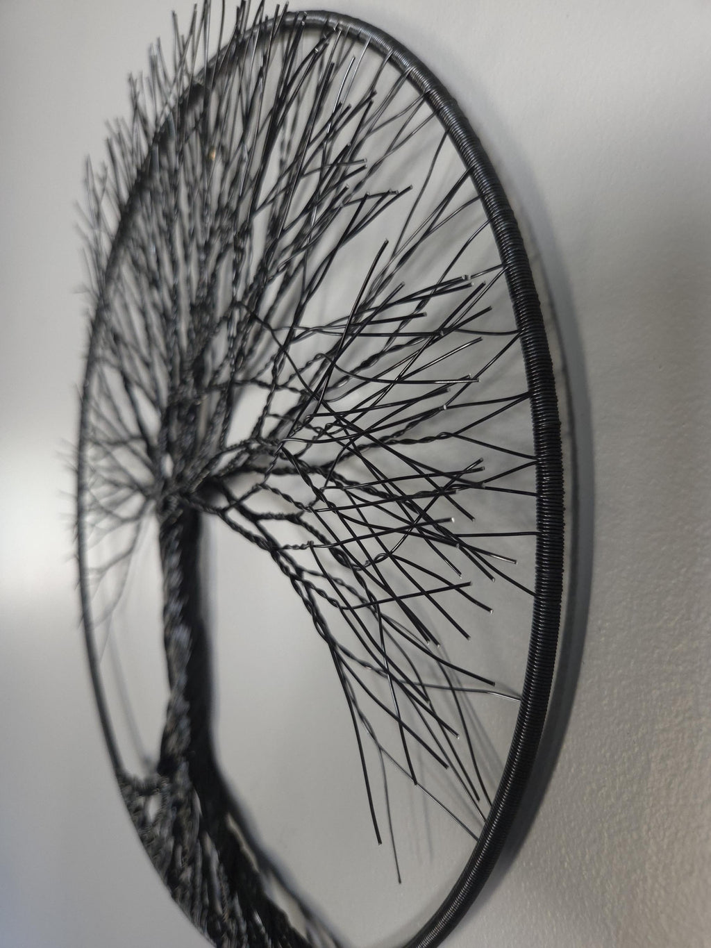 Decorative wall art of a tree with thin branches on a plain background