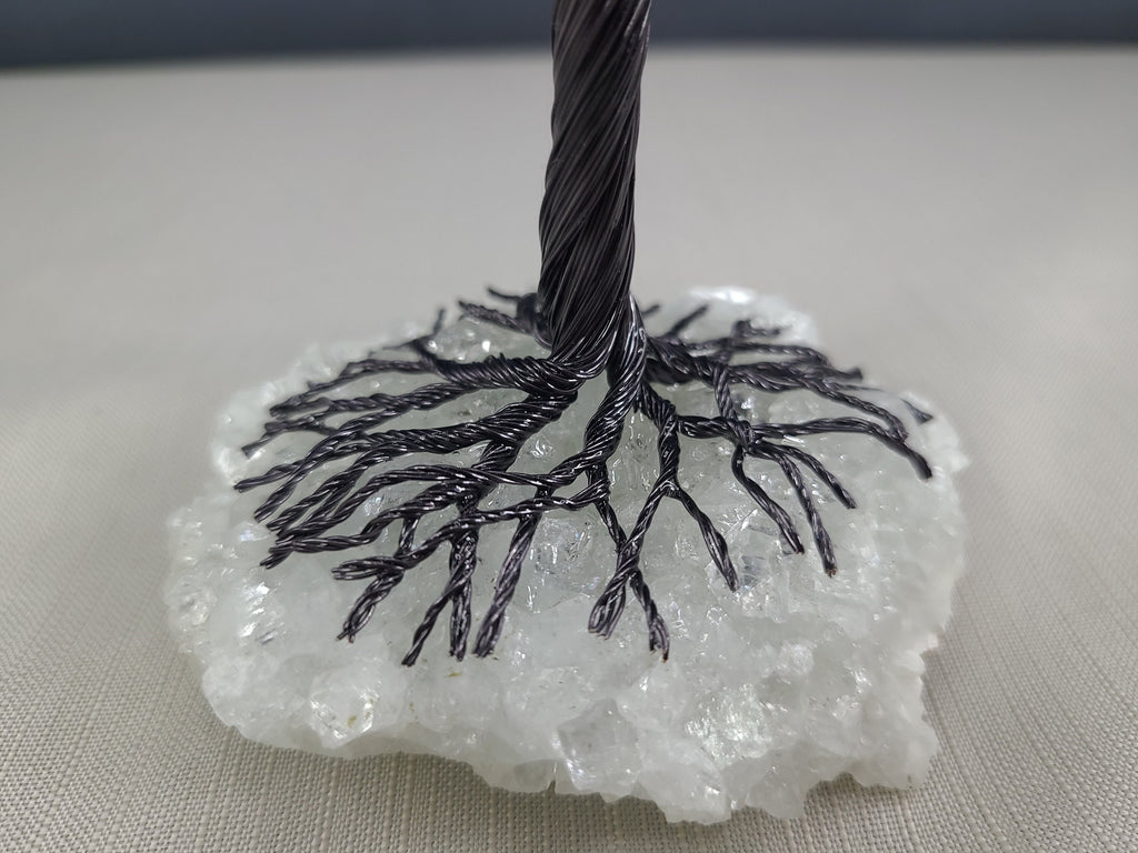 Black cable on a white crystal-like base against a neutral background