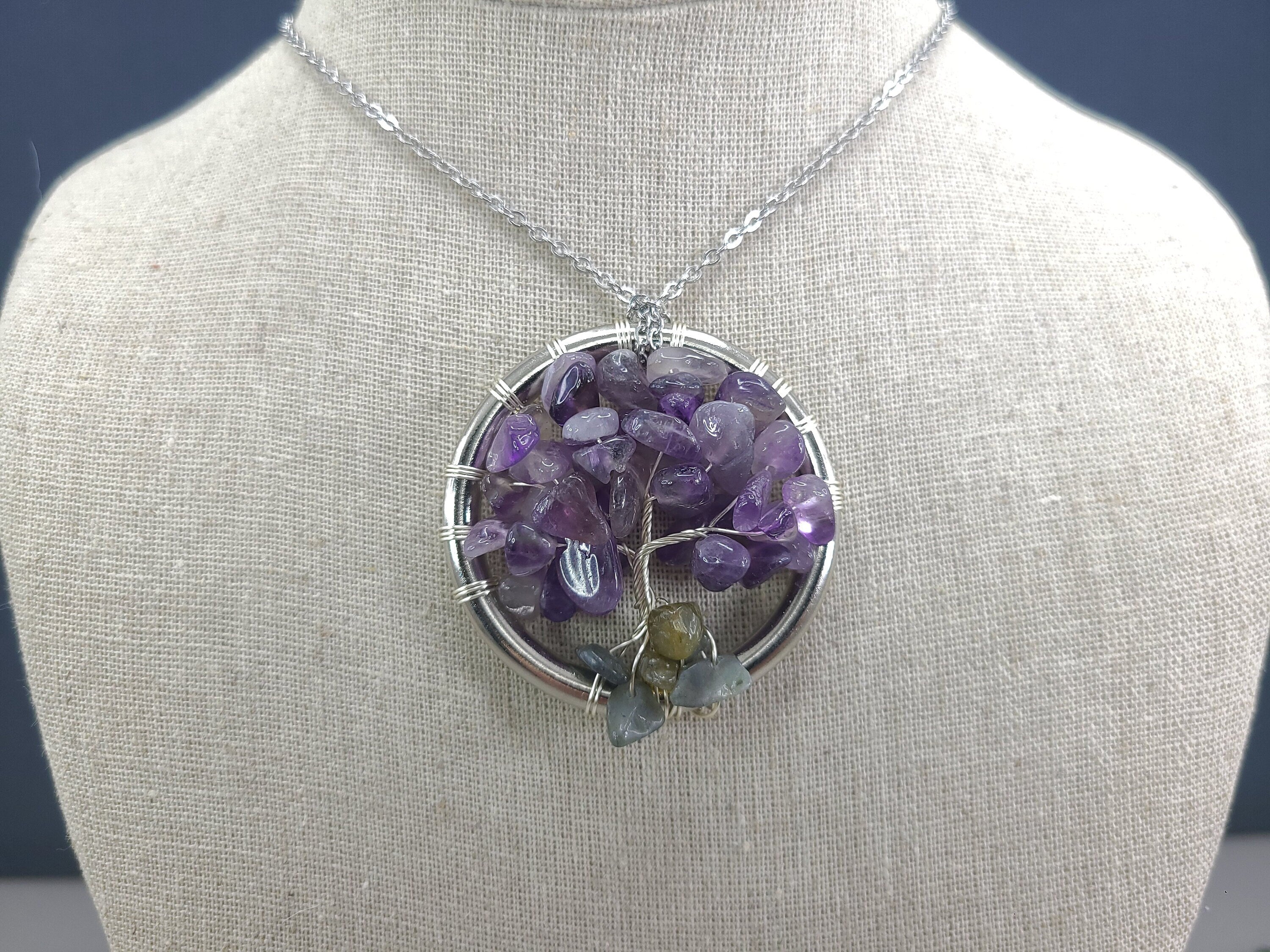 Amethyst tree of life pendant on a mannequin bust with a dark background