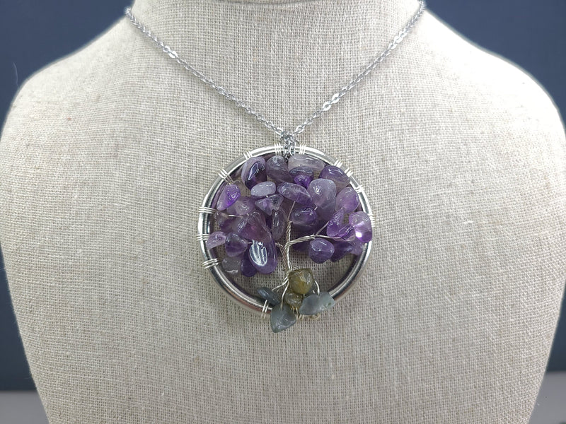 Amethyst tree of life pendant on a mannequin bust with a dark background