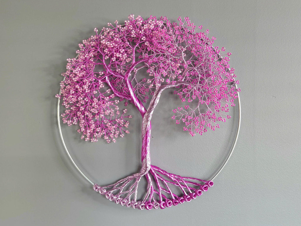 Decorative wall art of a tree with pink blossoms on a gray background