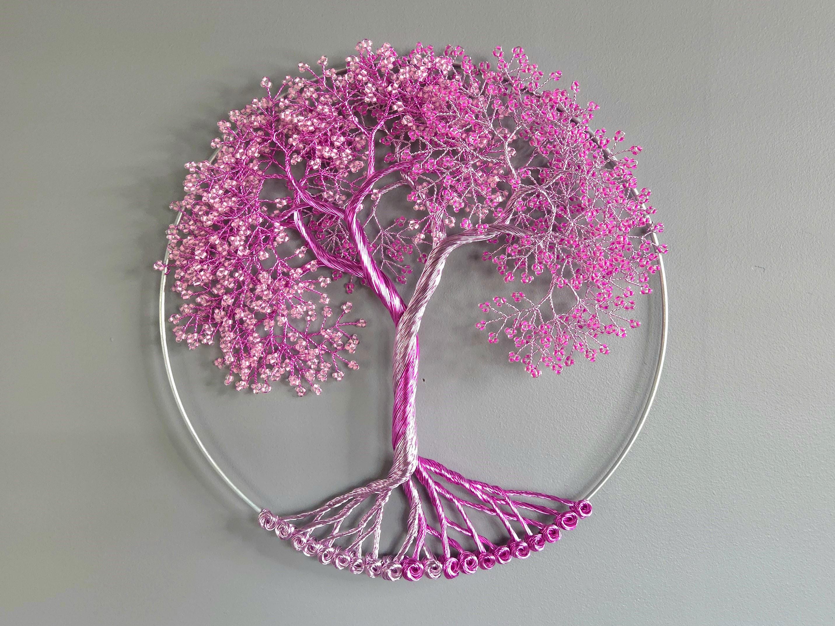Decorative wall art of a tree with pink blossoms on a gray background
