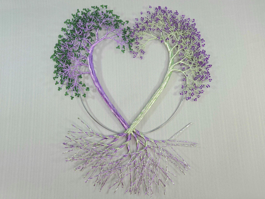 Heart-shaped design with trees made of branches and leaves on a light gray background