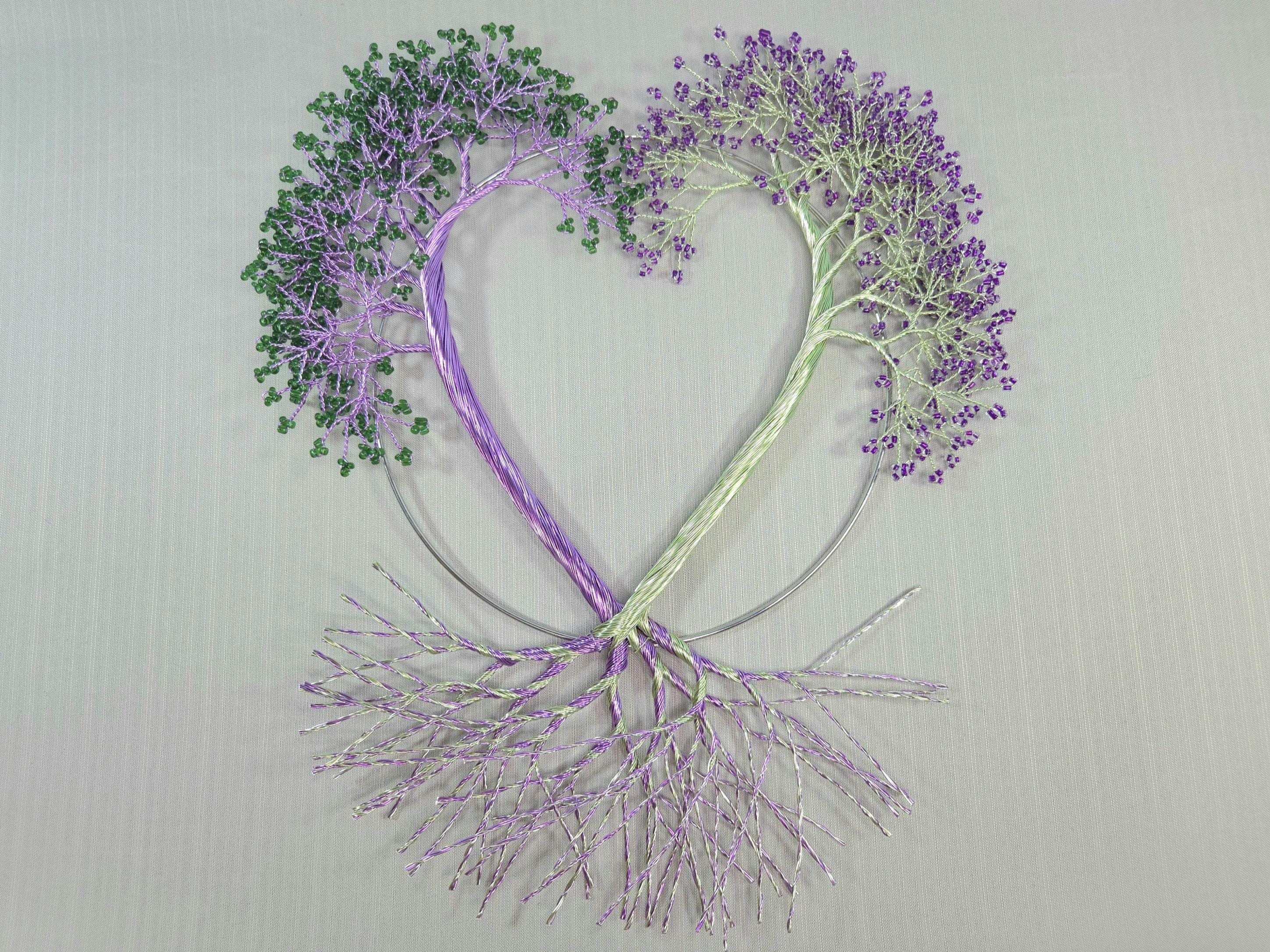 Heart-shaped design with trees made of branches and leaves on a light gray background