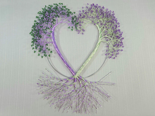Heart-shaped design with trees made of branches and leaves on a light gray background