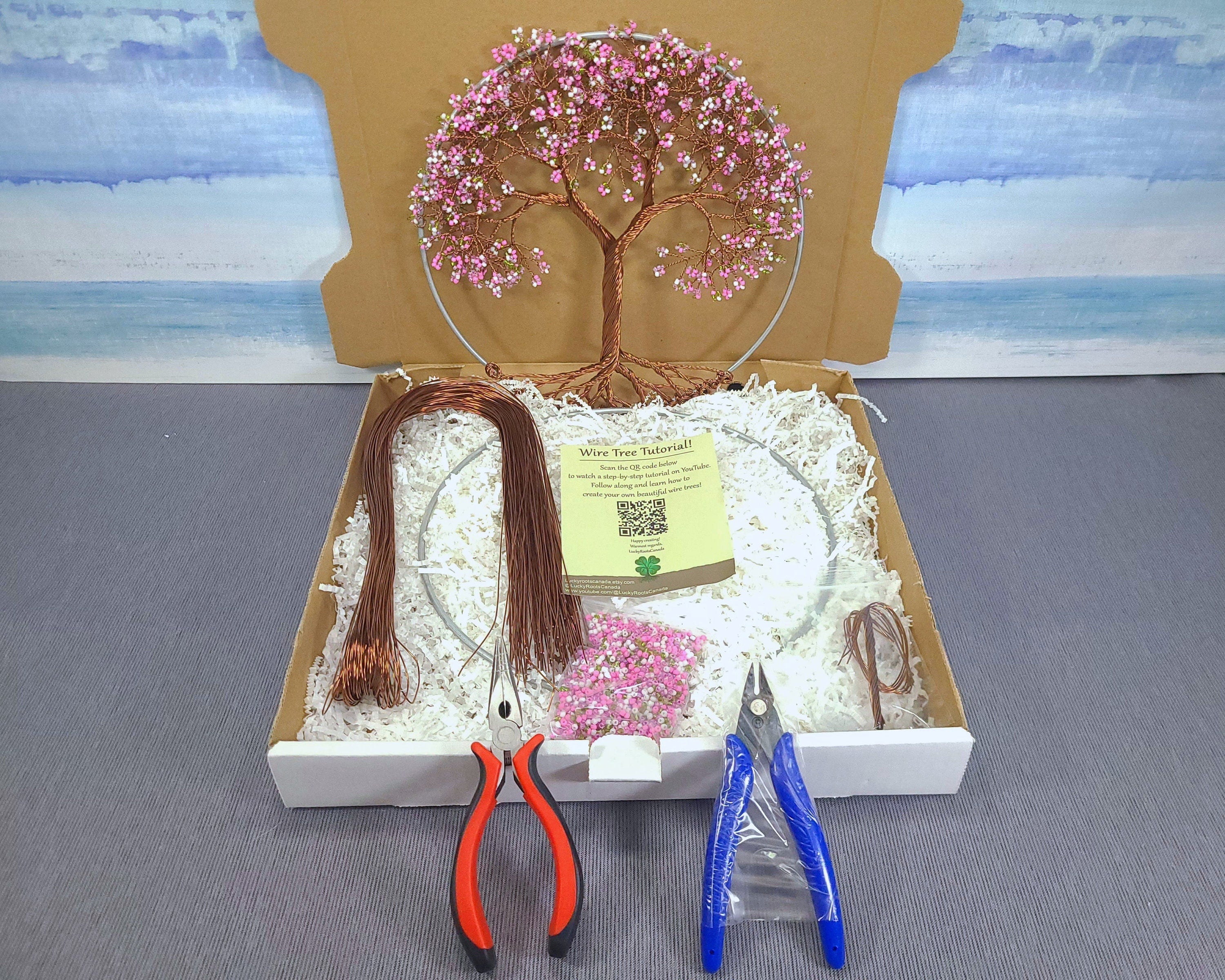 Craft kit with decorative tree, scissors, and pliers on a gray surface.