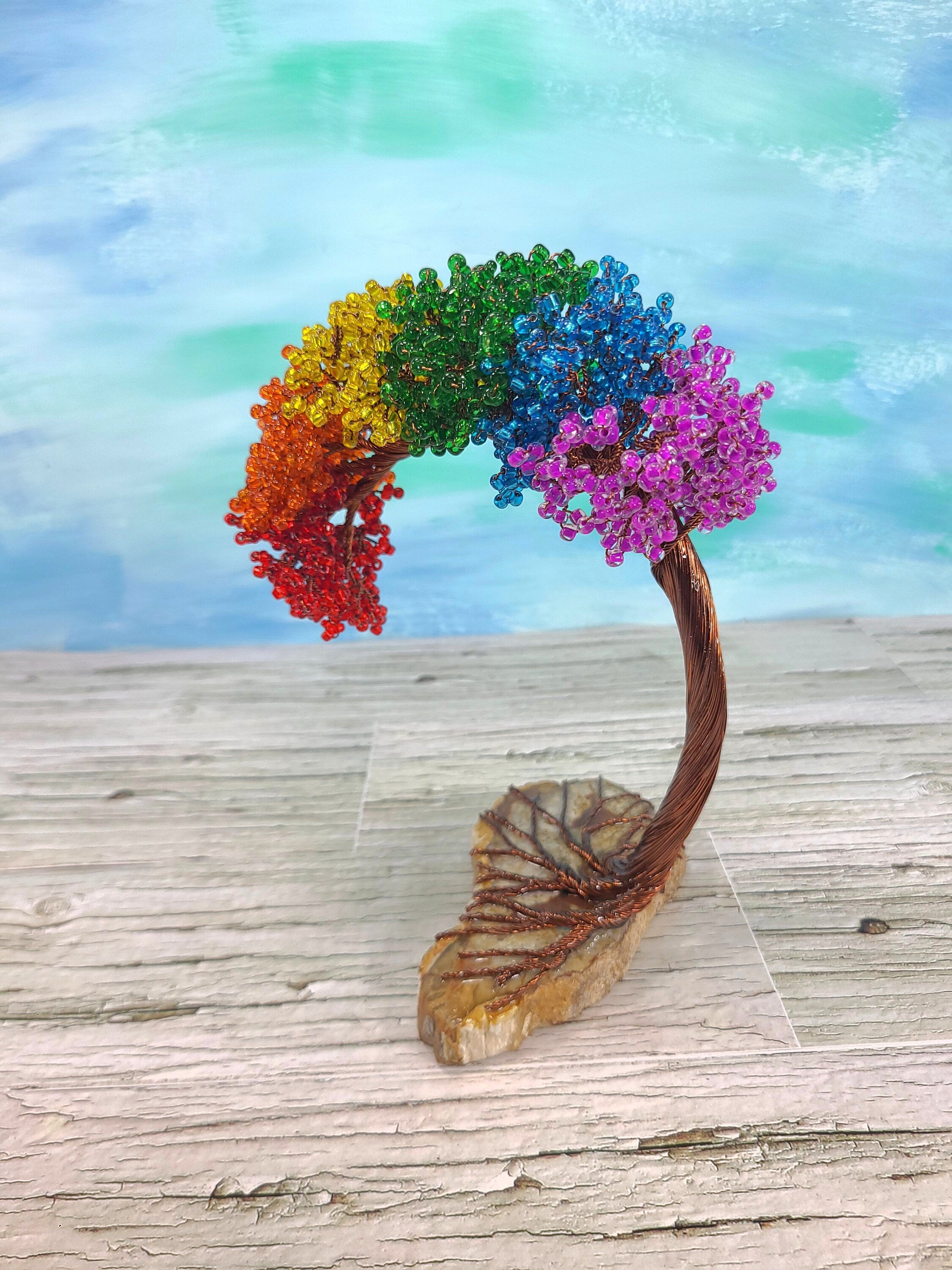 Colorful tree sculpture on a wooden surface with a blurred background