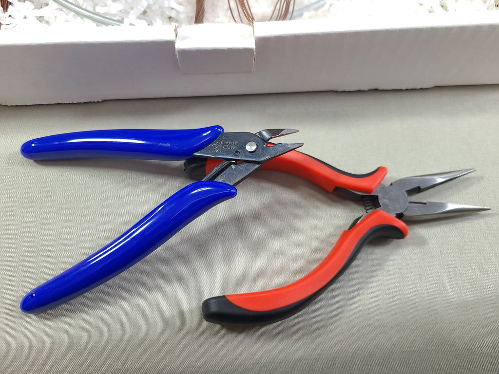 Pair of pliers with blue and red handles on a light gray surface