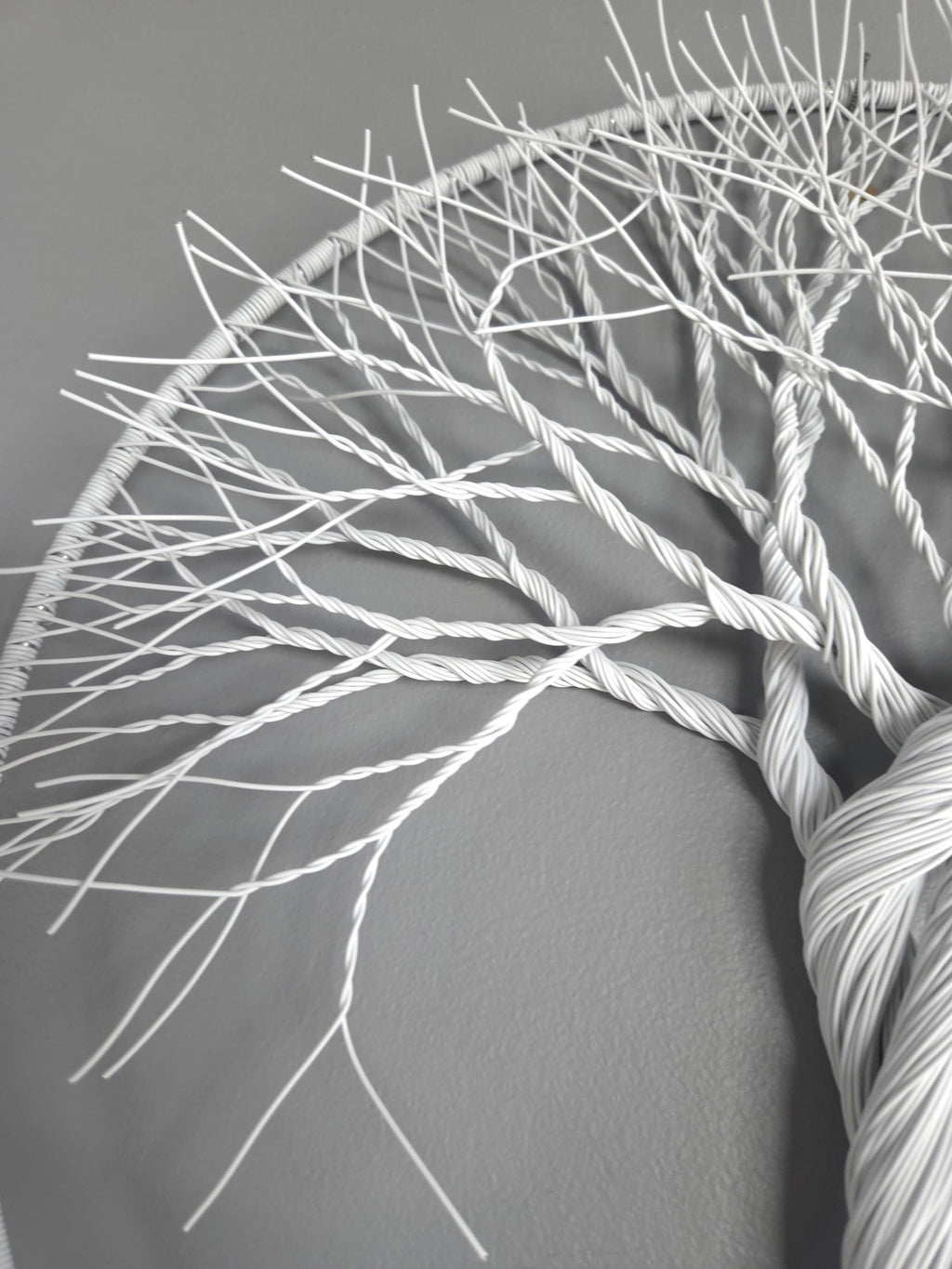 Close-up of white yarn skein with intricate patterns on a gray background