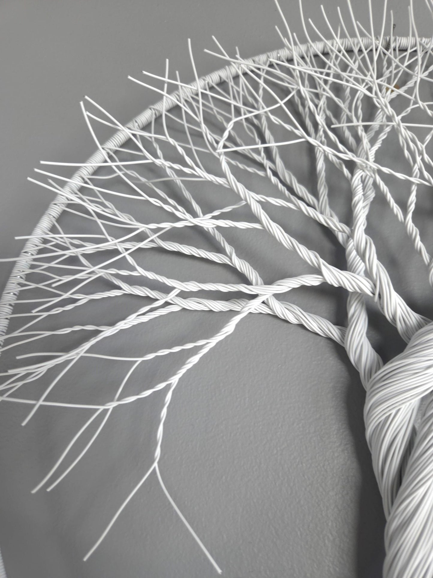 Close-up of white yarn skein with intricate patterns on a gray background