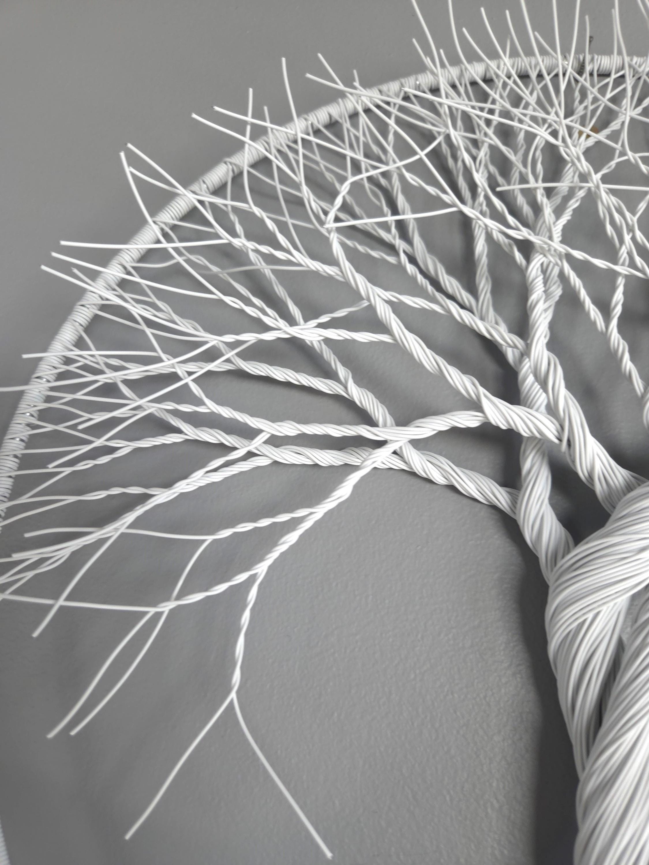 Close-up of white yarn skein with intricate patterns on a gray background