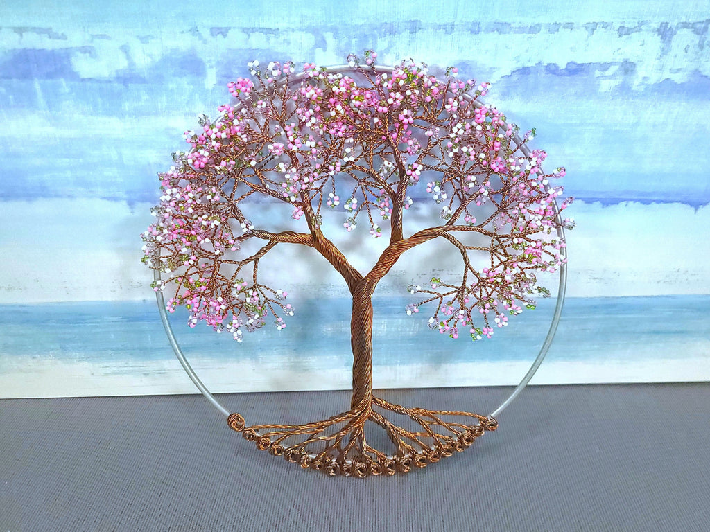 Decorative tree sculpture with pink flowers on a blue and white abstract background