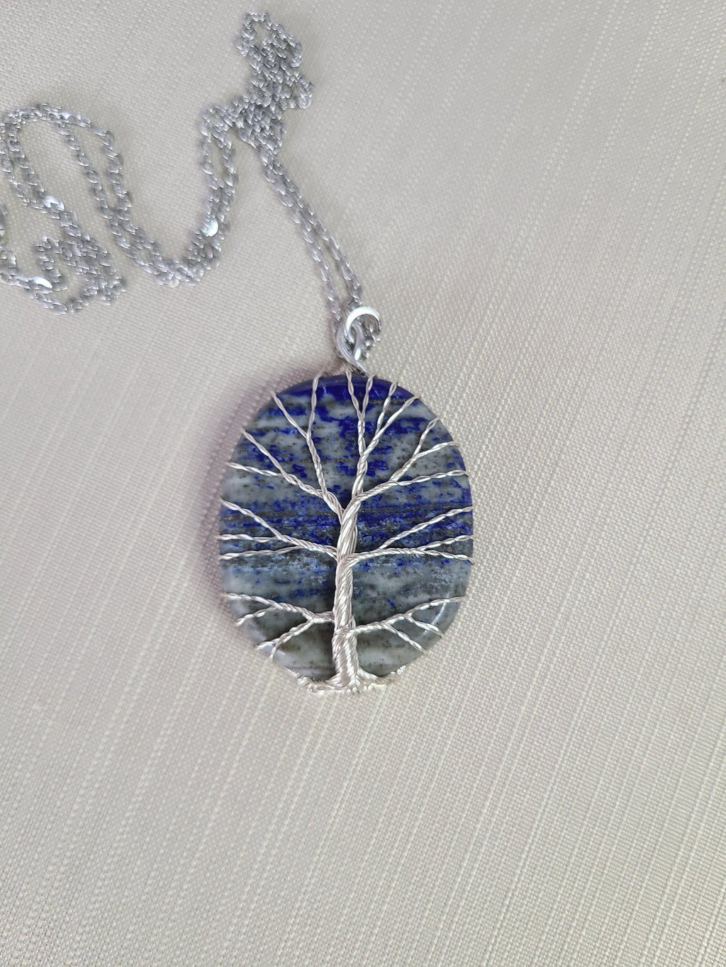 Necklace with a tree-shaped pendant on a light gray background