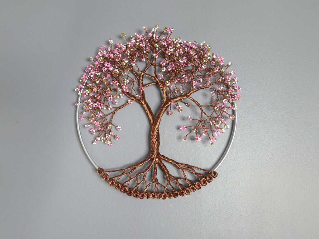 Decorative wall art of a tree with pink blossoms on a gray background