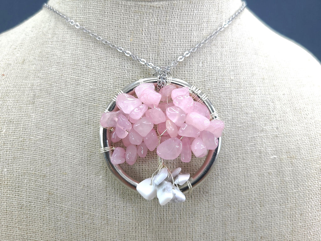 Pink gemstone necklace on a mannequin bust with a neutral background