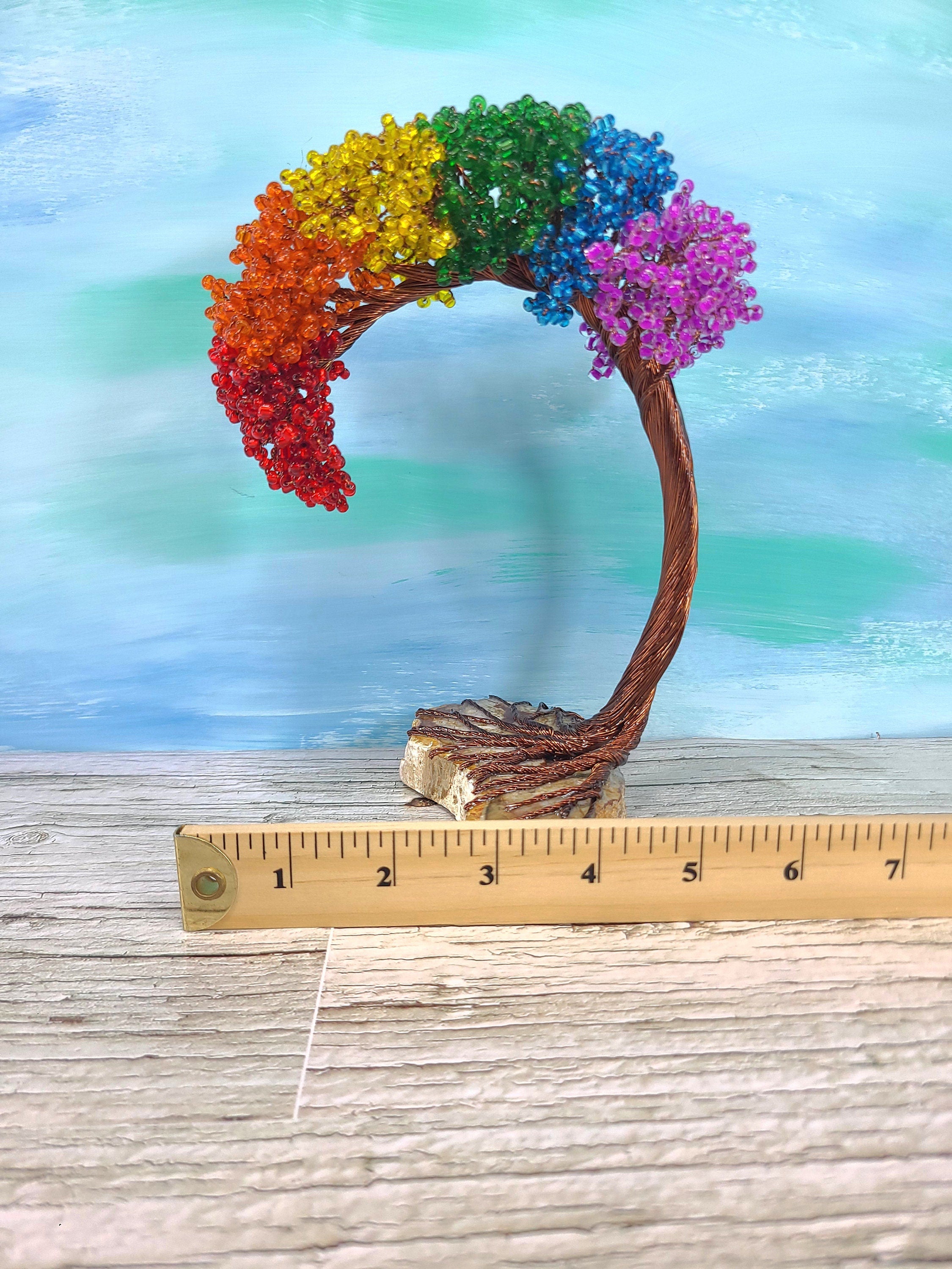 Colorful bonsai tree with a ruler for scale on a wooden surface