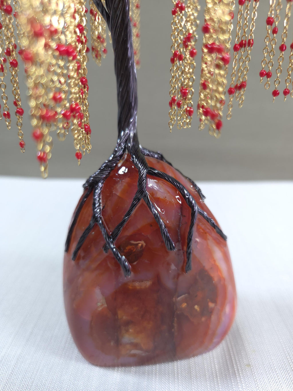 Decorative tree with red berries and gold branches on a white background