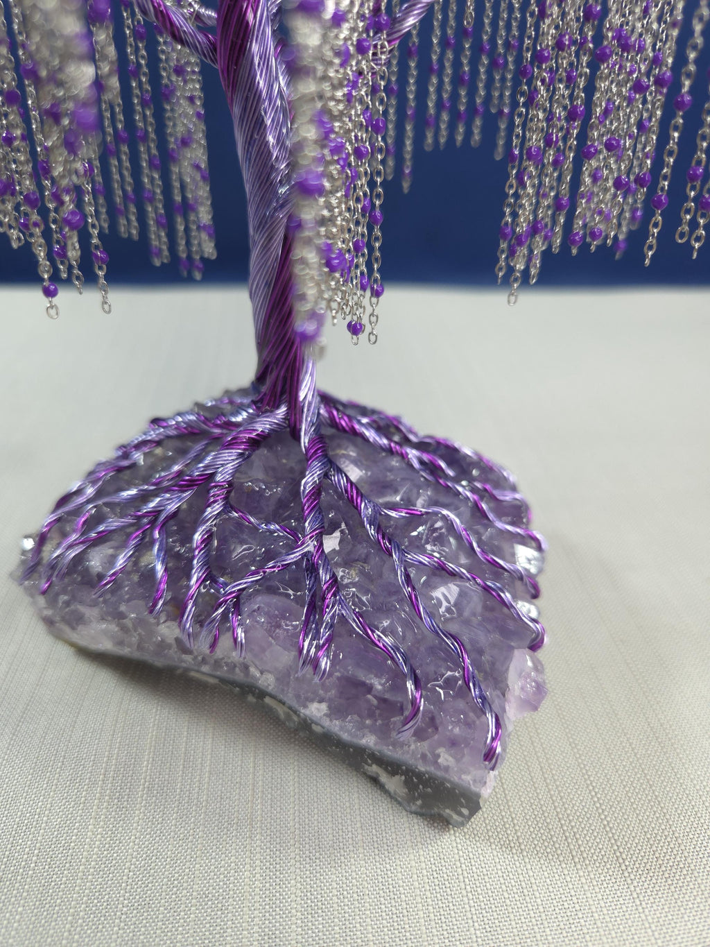 Decorative piece with purple and silver elements on a textured surface
