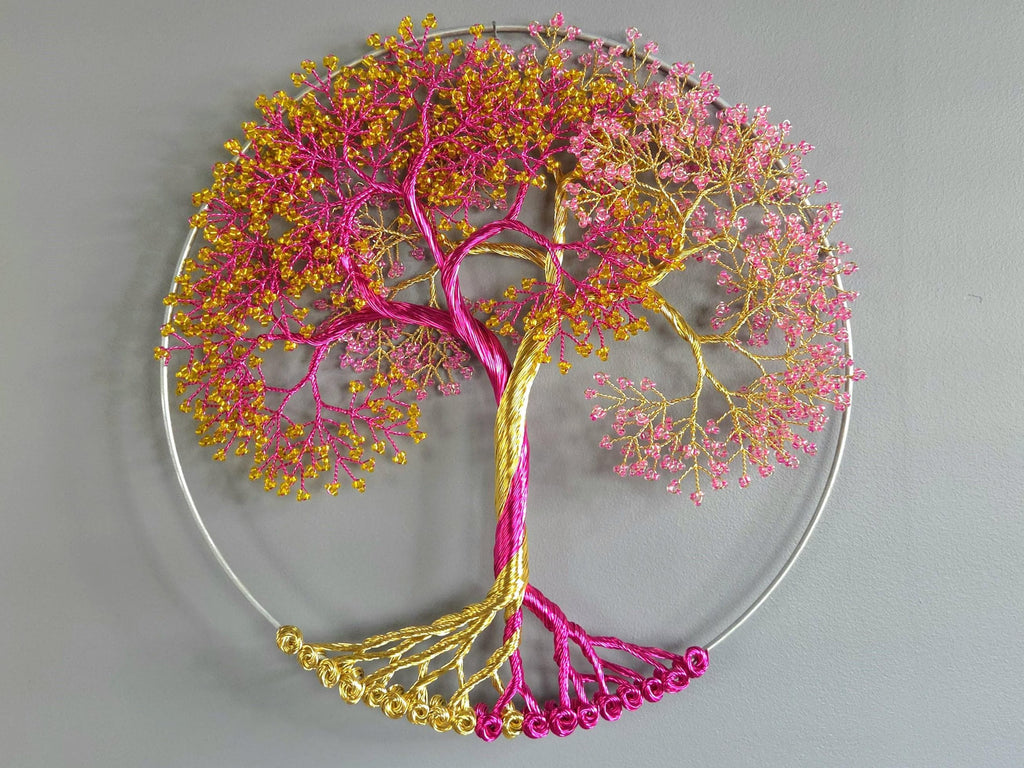 Decorative wall art of a tree with pink and gold branches on a gray background