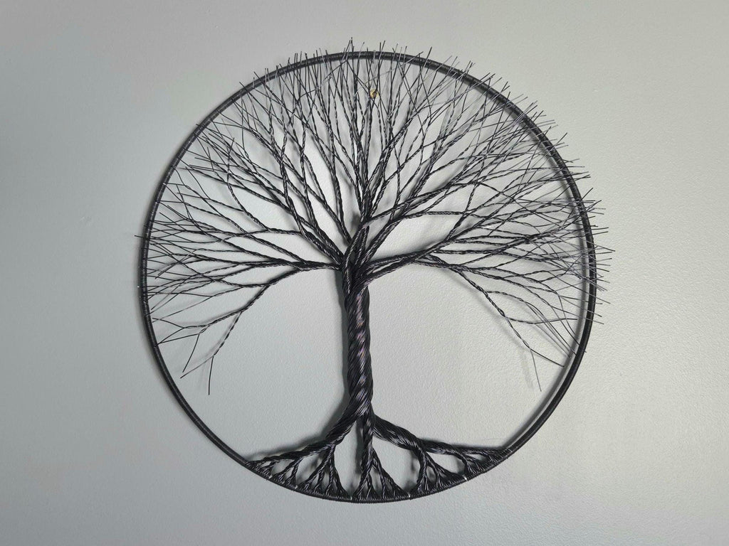 Decorative wall art of a tree with a peace symbol on a plain background