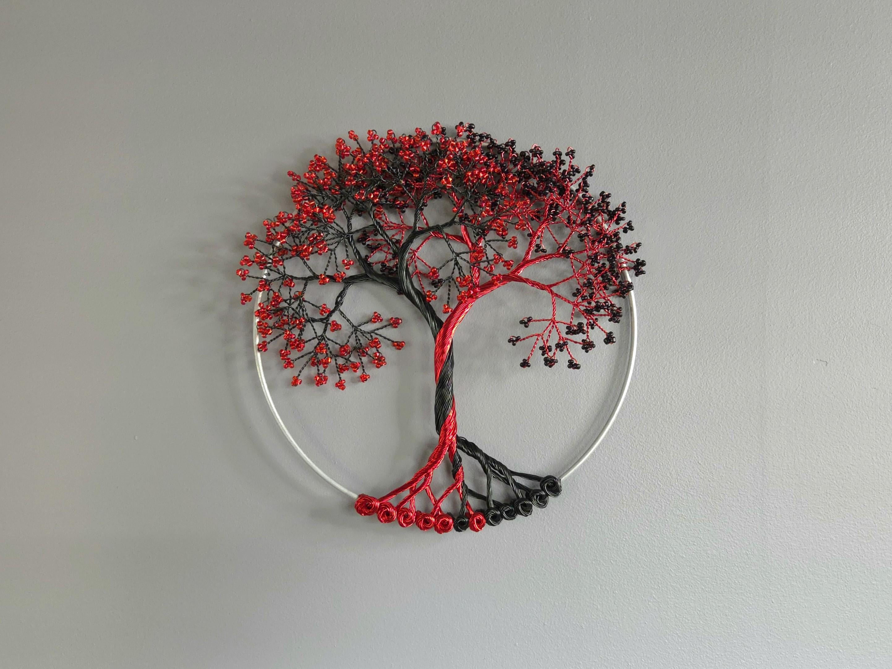 Decorative wall art of a tree with red and black branches on a gray background
