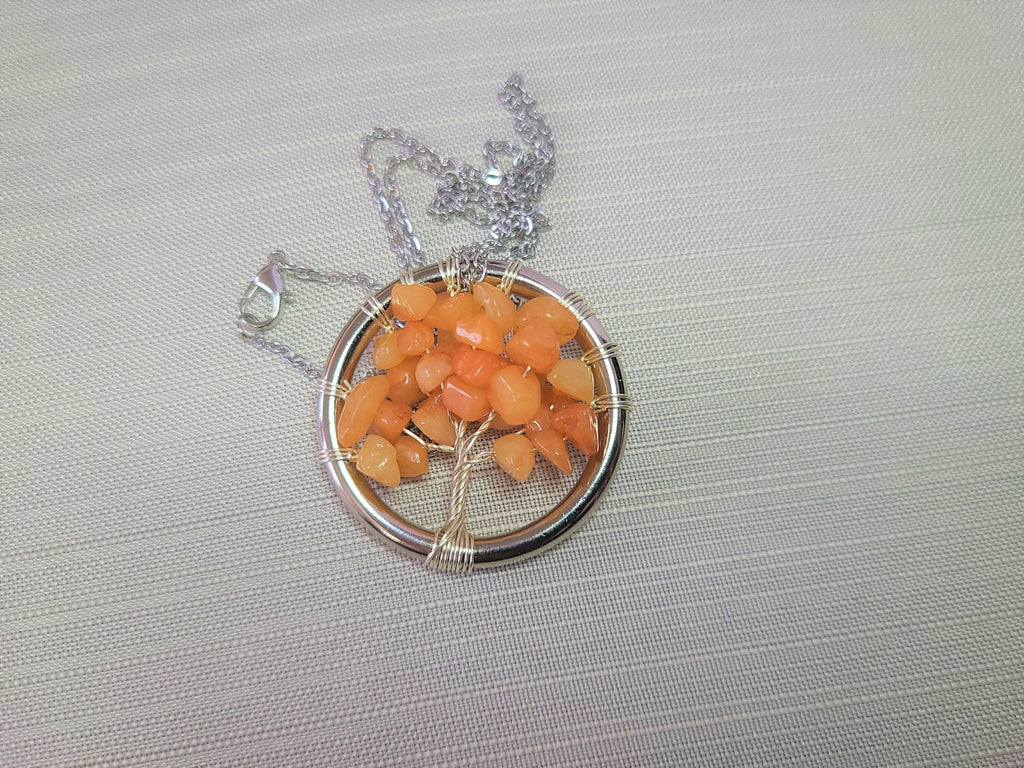 Necklace with a circular pendant featuring orange stones on a gray background