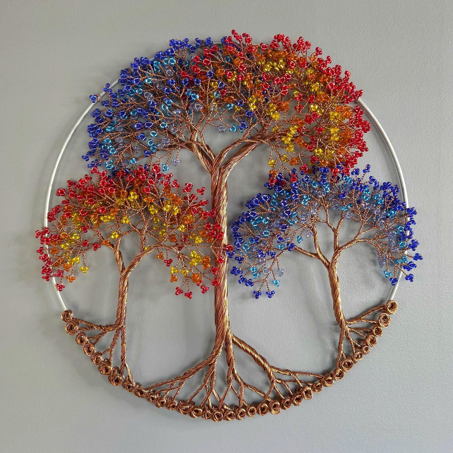 Decorative wall art of a tree with colorful leaves on a plain background