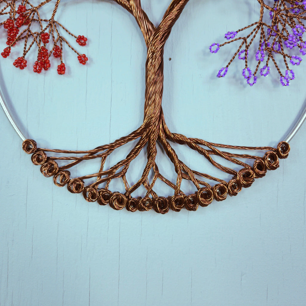 Decorative wall art with a wire tree design on a light blue background