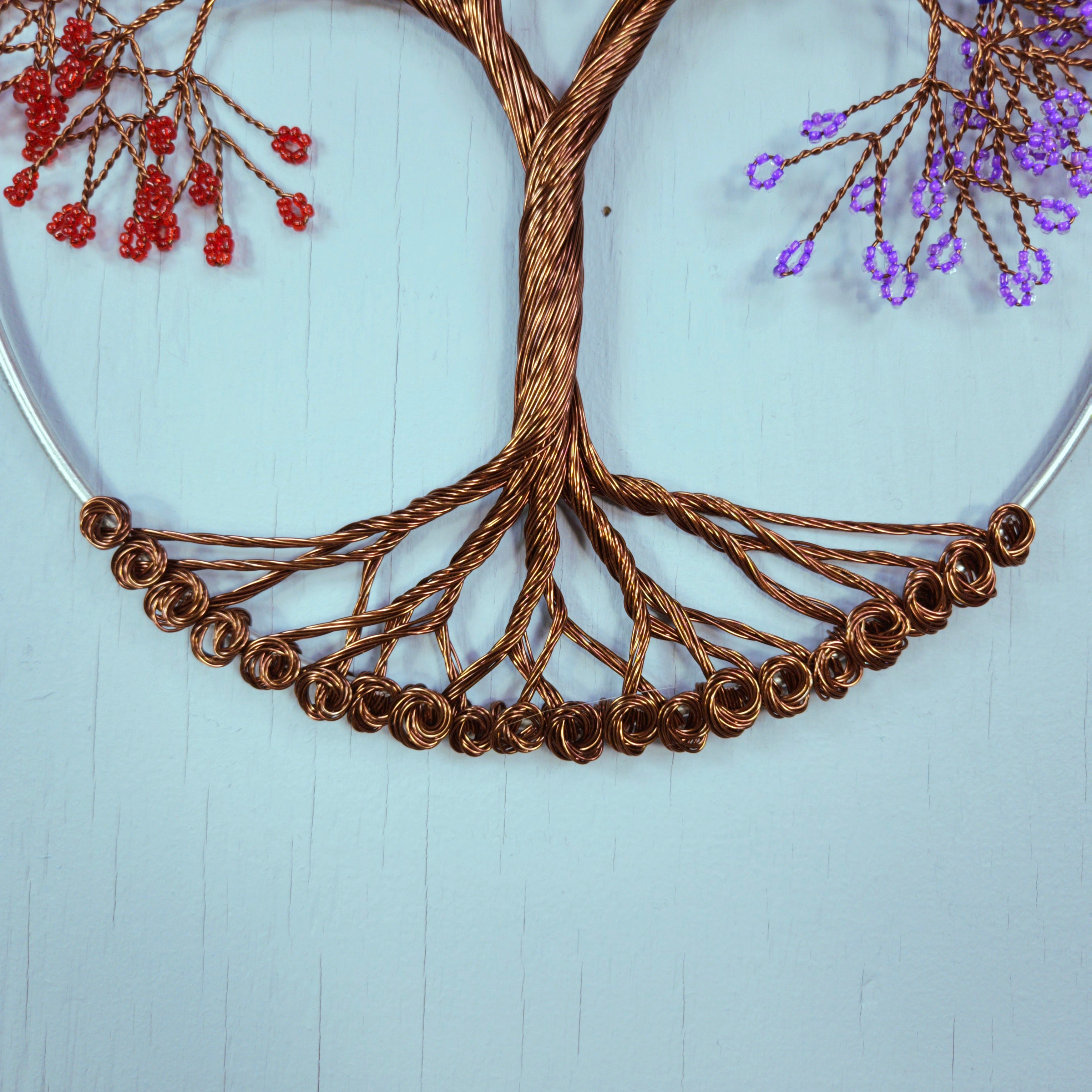 Decorative wall art with a wire tree design on a light blue background