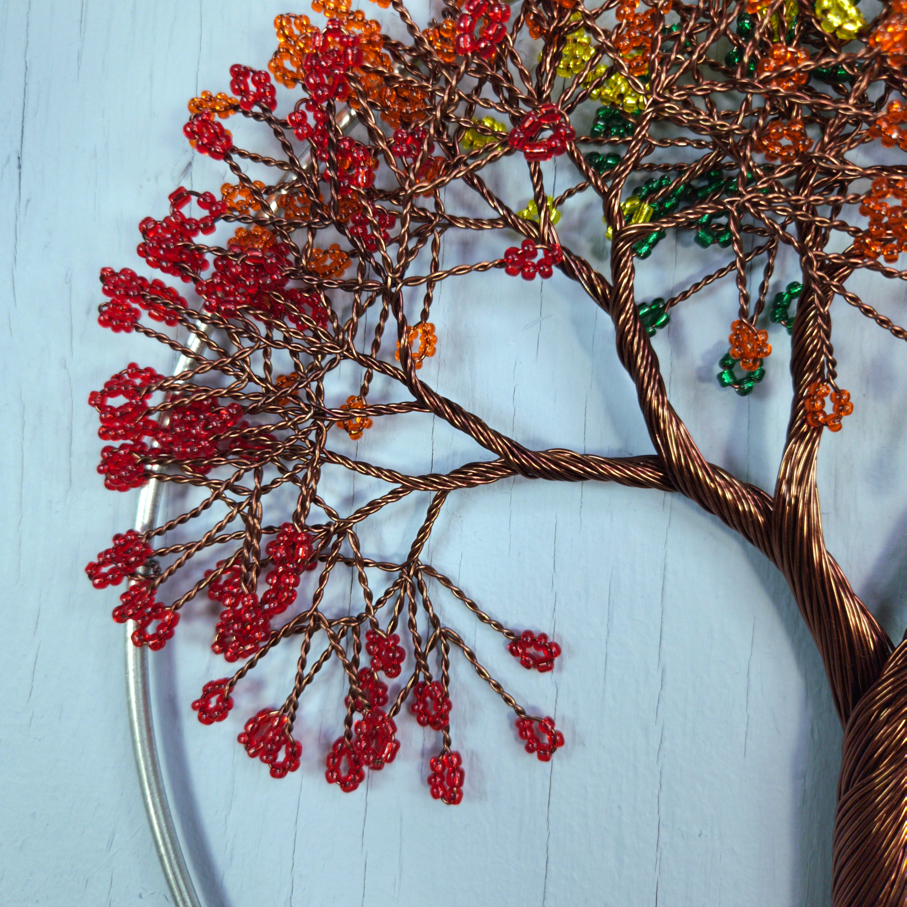 Decorative wire tree with colorful beads on a light blue background